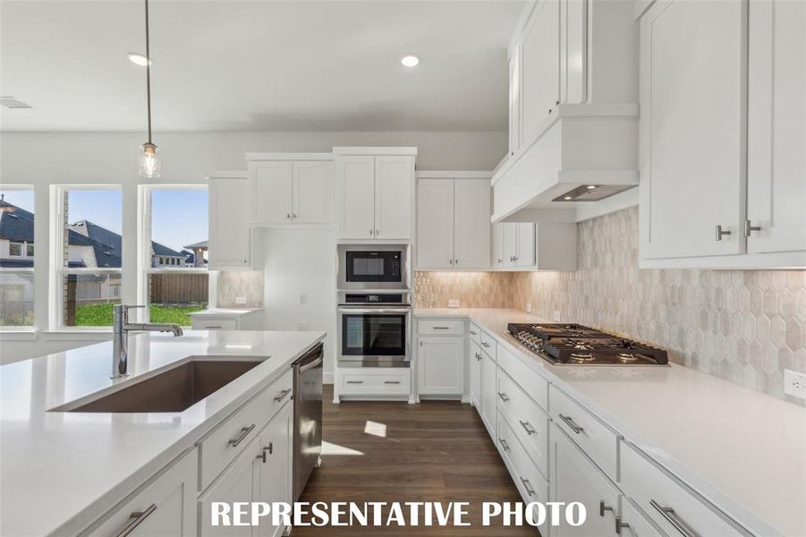 Beautiful cabinetry, gorgeous countertops and designer backsplash effortlessly pair with contemporary stainless steel to create a kitchen for the ages!  REPRESENTATIVE PHOTO