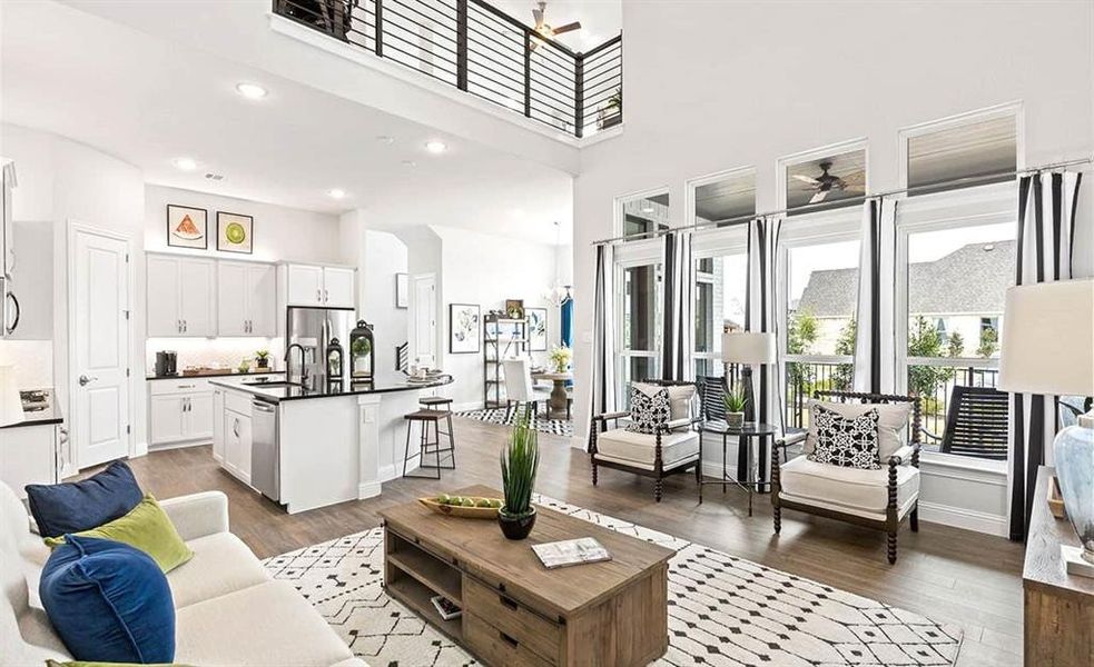 Living room featuring a towering ceiling, hardwood / wood-style flooring, sink, and ceiling fan