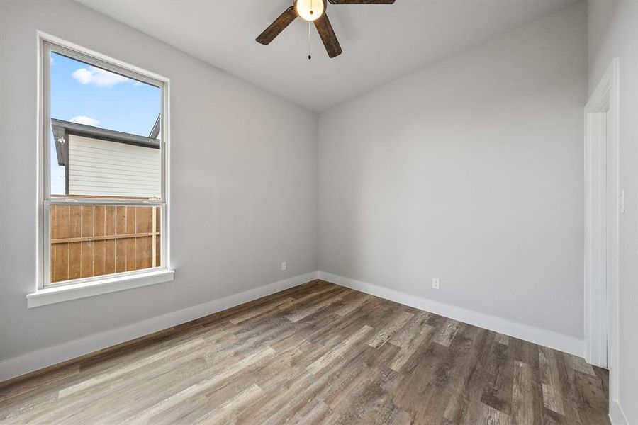 Empty room with wood finished floors and ceiling fan