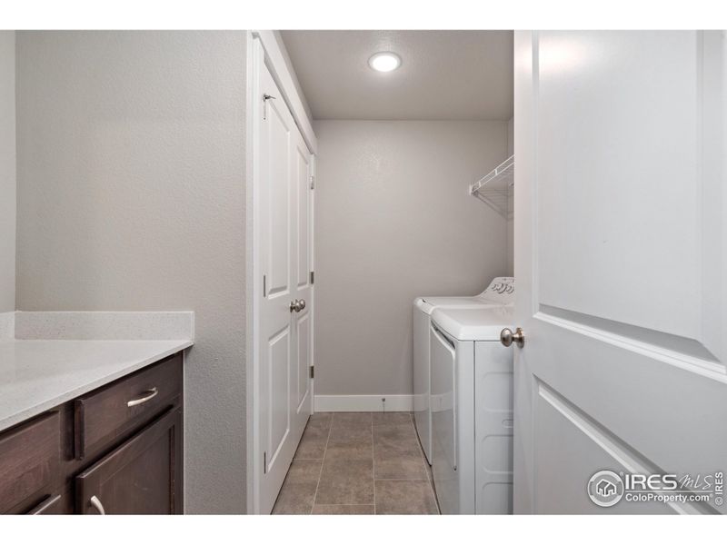 full laundry room w/ built in cabinets & quartz countertops