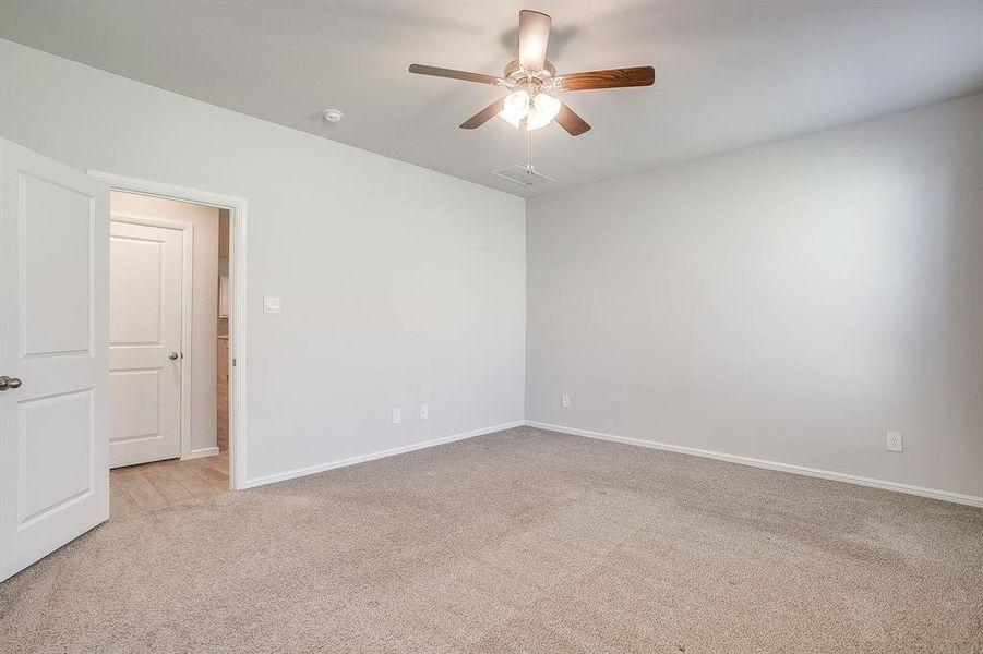 Spare room featuring light carpet and ceiling fan