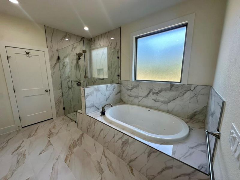 Bathroom featuring a marble finish shower, a bath, light marble finish flooring, and recessed lighting