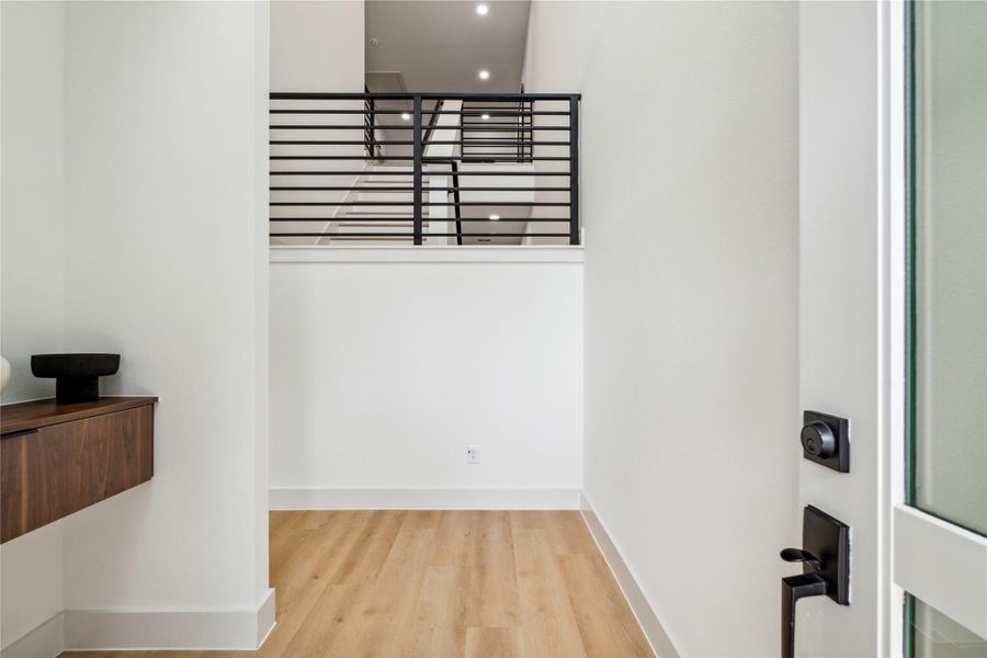 Step into a striking foyer with crisp modern lines, elevated sightlines, and sleek built-in storage that sets a sophisticated tone from the moment you arrive.