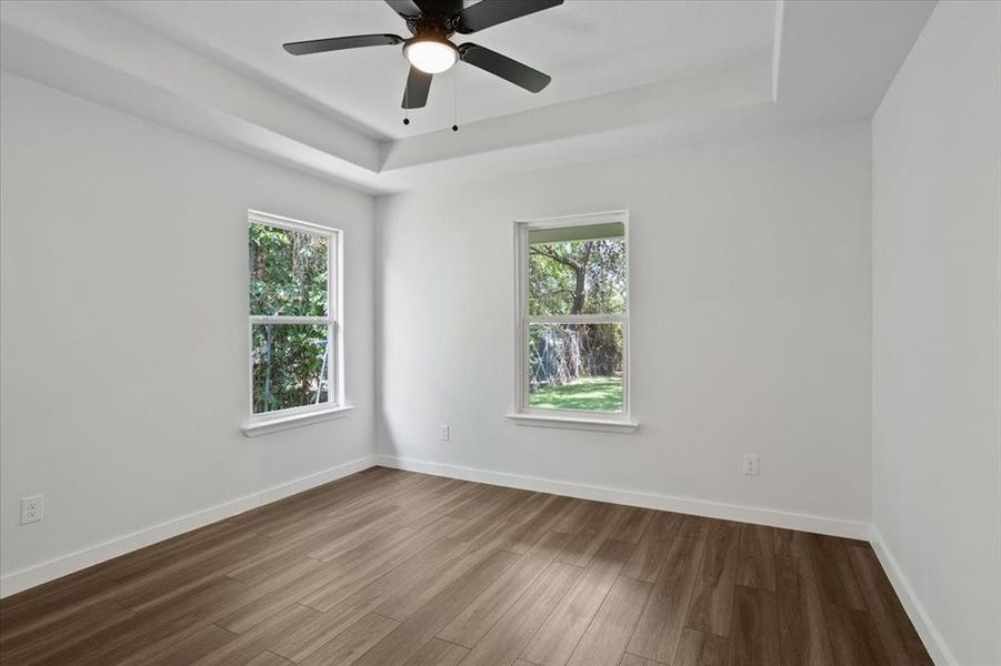 Unfurnished room featuring a healthy amount of sunlight, hardwood / wood-style flooring, and ceiling fan