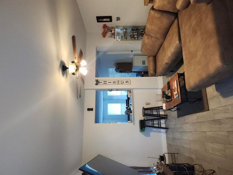 Living area featuring light wood-style flooring and ceiling fan
