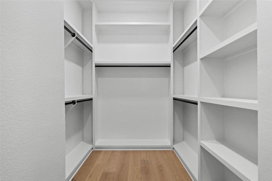 Tailored storage, thoughtfully resolved: custom millwork wraps the walk-in with double-hang bays, open shelving, and a central long-hang niche for statement pieces. Clean lines and dark wardrobe rods lend a tailored contrast, transforming everyday organization into a quietly luxurious ritual. Tailored storage, thoughtfully resolved: custom millwork wraps the walk-in with double-hang bays, open shelving, and a central long-hang niche for statement pieces. Clean lines and dark wardrobe rods lend a tailored contrast, transforming everyday organization into a quietly luxurious ritual.