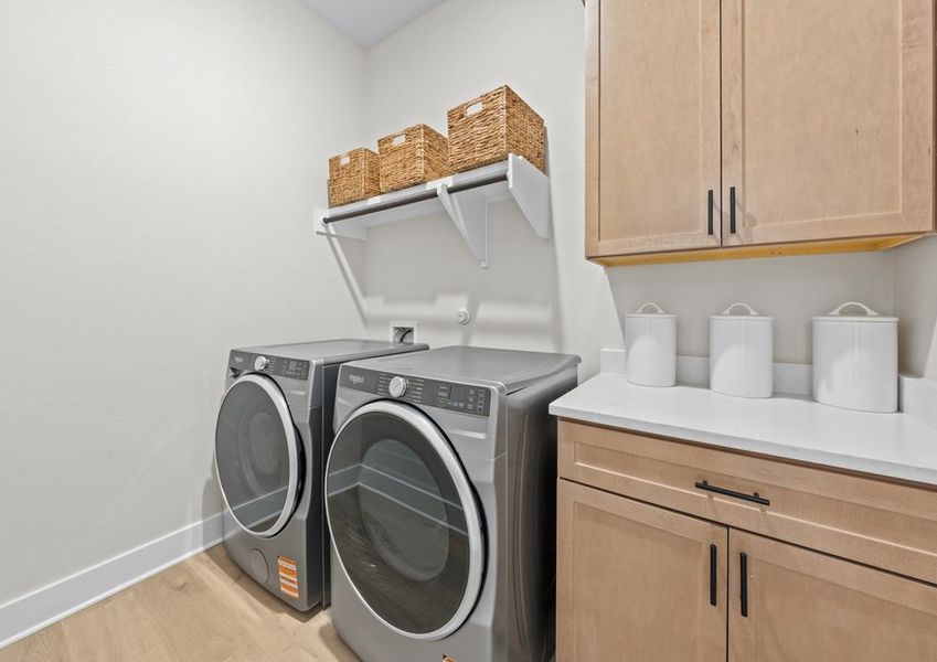 The laundry room has cabinets and counterspace.