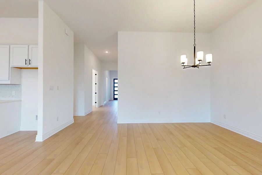 The property features light-toned hardwood flooring, a modern chandelier, and recessed lighting in the hallway