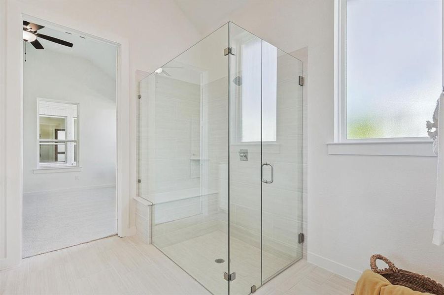 Bathroom with vaulted ceiling, ceiling fan, a shower with door, and tile patterned floors