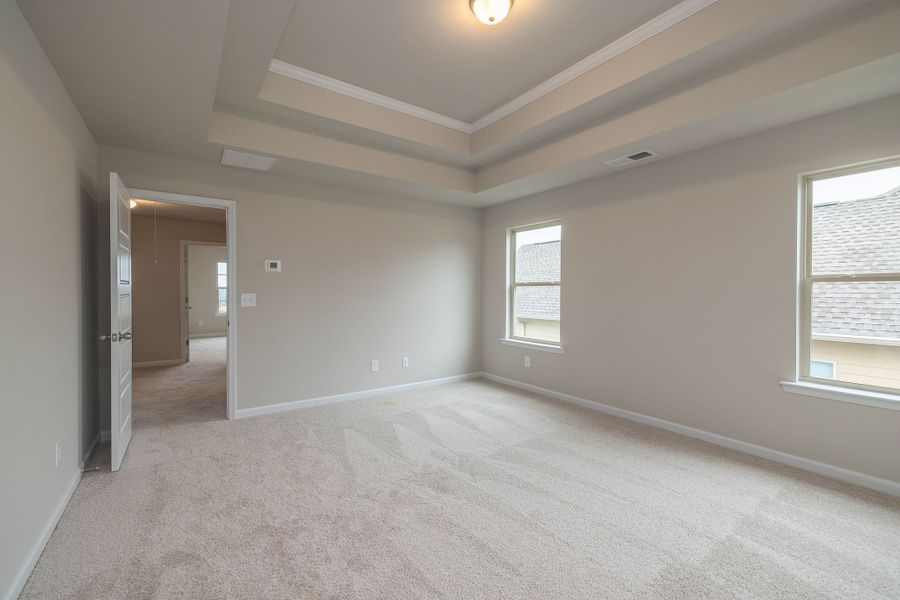 Oversized primary bedroom with trey ceiling located upstairs