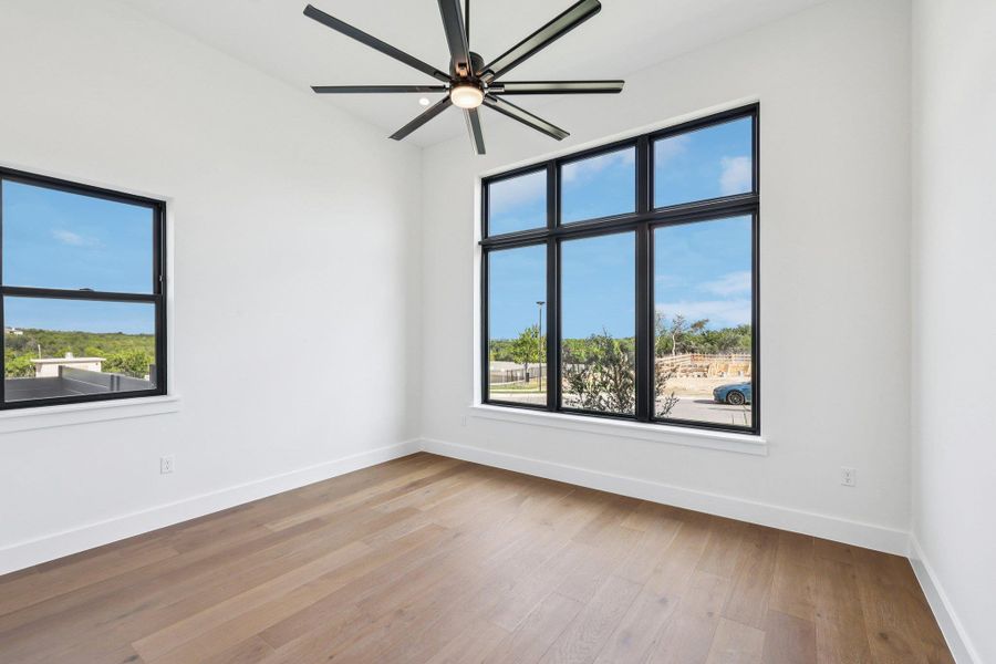 Unfurnished room featuring healthy amount of natural light, light wood-style flooring, and a ceiling fan