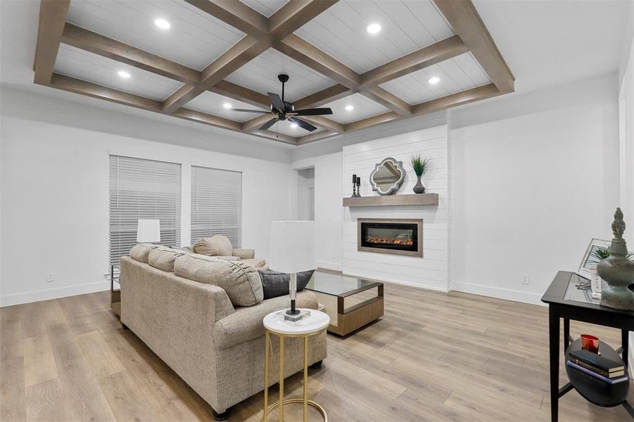 Living room with ceiling fan, beam ceiling, light hardwood / wood-style flooring, and coffered ceiling