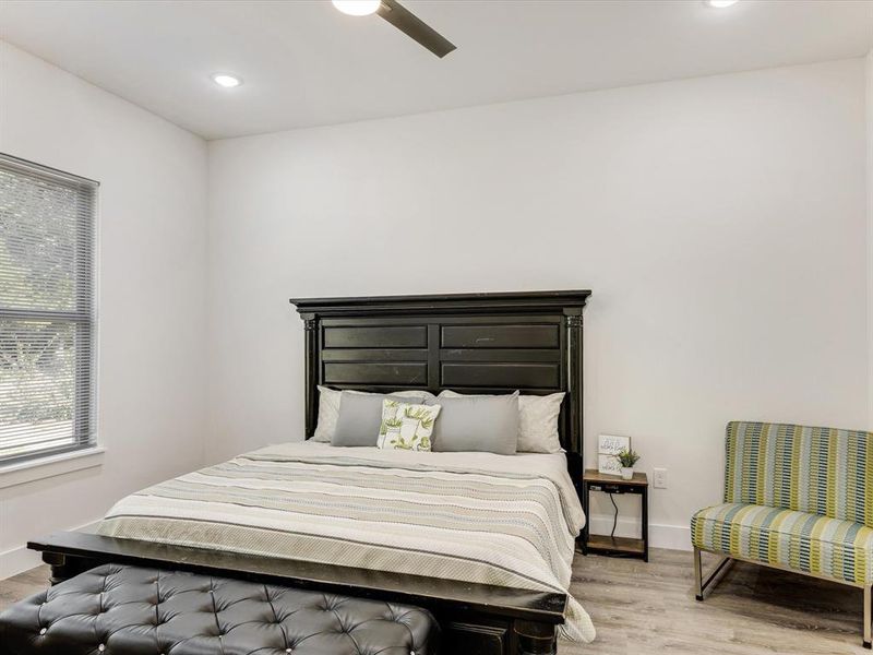 Bedroom featuring light wood-type flooring, ceiling fan, and recessed lighting