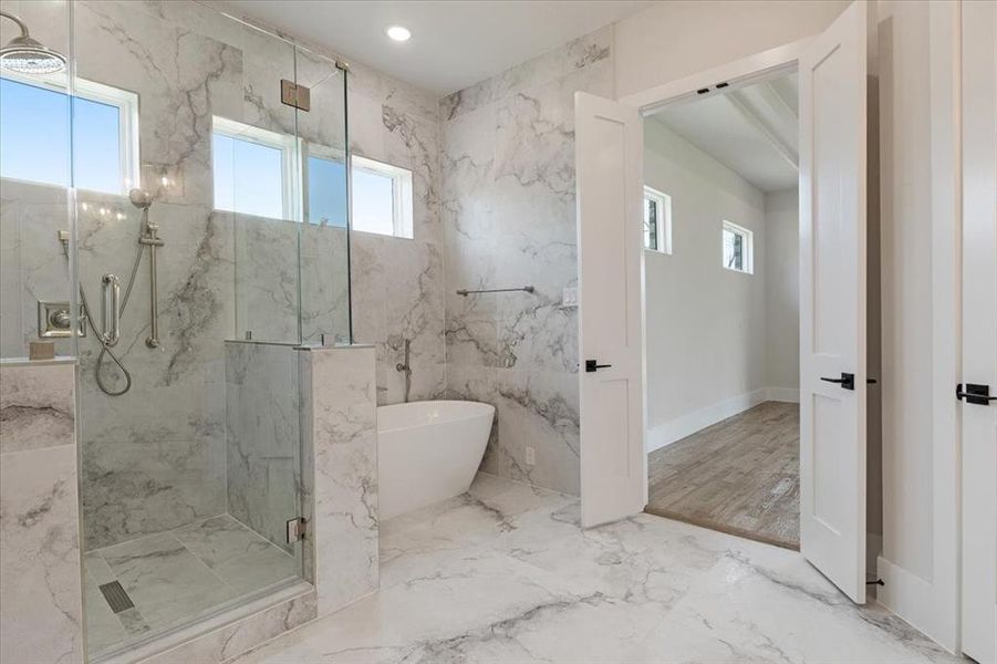 Bathroom featuring shower with separate bathtub, plenty of natural light, and tile floors