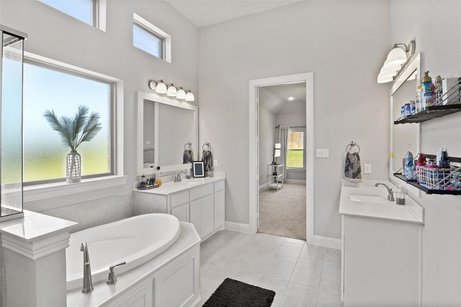 Bathroom with a bathing tub, vanity, and tile patterned floors