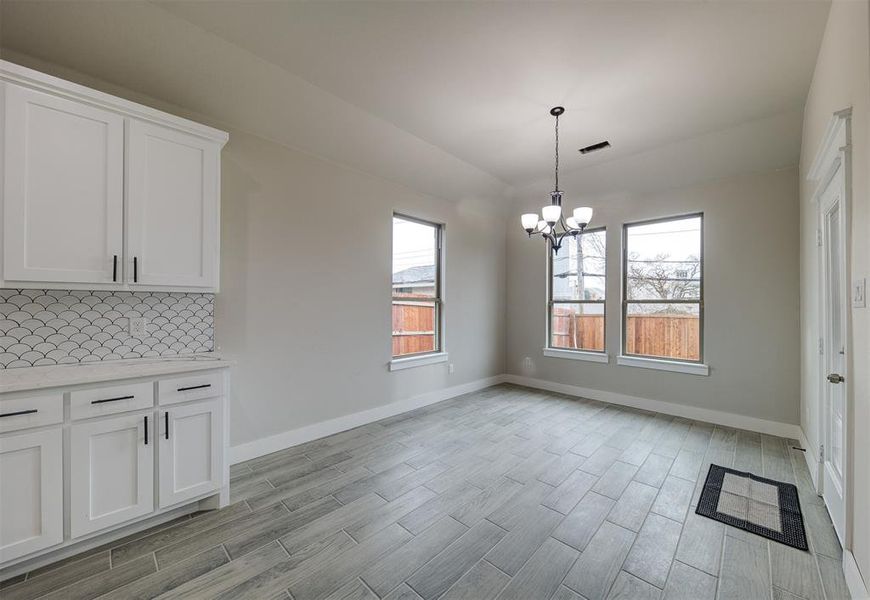 Unfurnished dining area featuring a notable chandelier