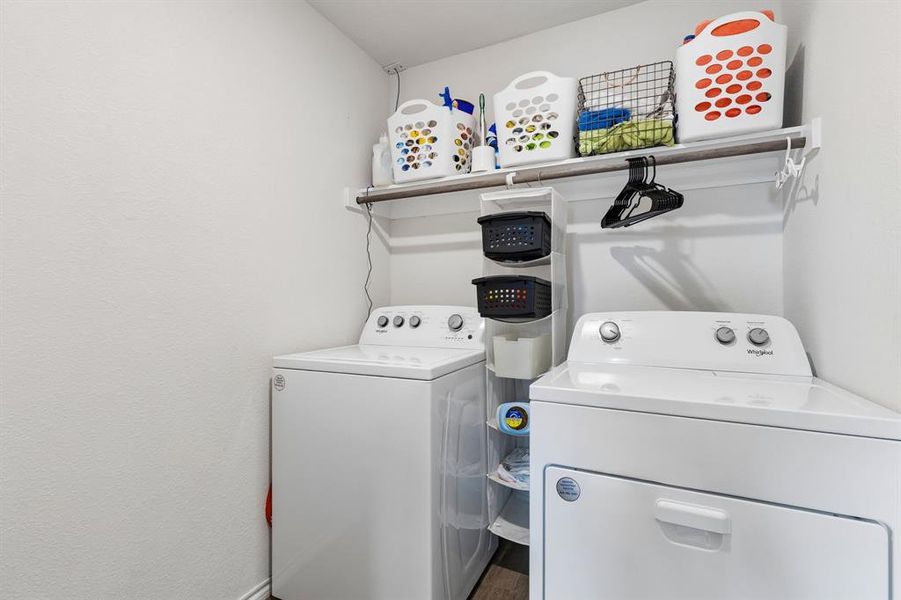 Laundry area featuring washing machine and dryer and wood finished floors Laundry area featuring washing machine and dryer and wood finished floors