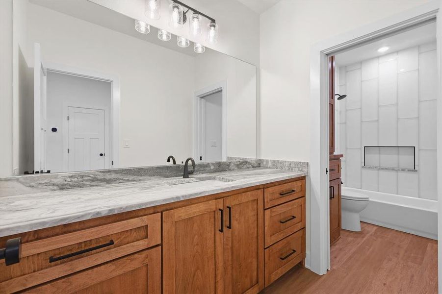 Bathroom featuring vanity, light wood-style floors, and shower / washtub combination