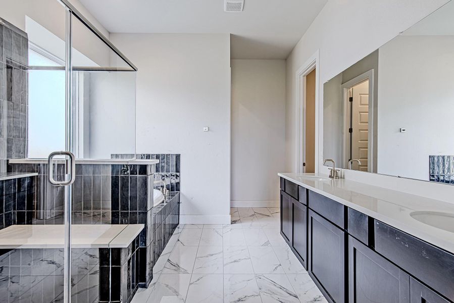 Spacious bath features a long quartz vanity, modern fixtures, and abundant storage. Spacious bath features a long quartz vanity, modern fixtures, and abundant storage.