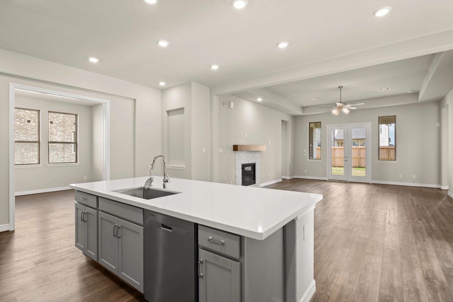Kitchen open to family room. Note: Sample product photo - actual exterior and interior selections may vary.