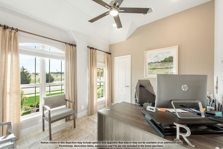 Home office with vaulted ceiling, ceiling fan, large windows, and wood desk with computer monitor