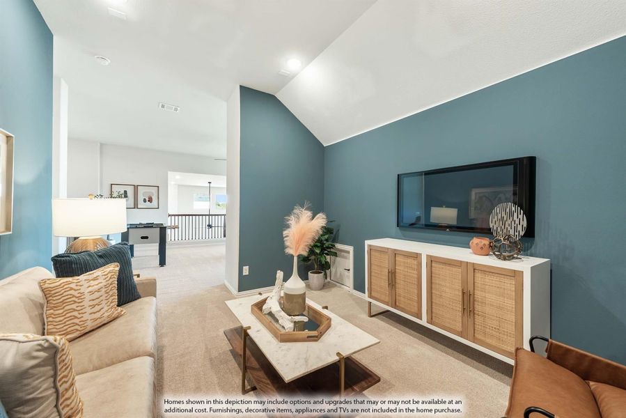 Living room with vaulted ceiling, blue accent wall, wall-mounted TV, and carpeted floor open to loft area Living room with vaulted ceiling, blue accent wall, wall-mounted TV, and carpeted floor open to loft area