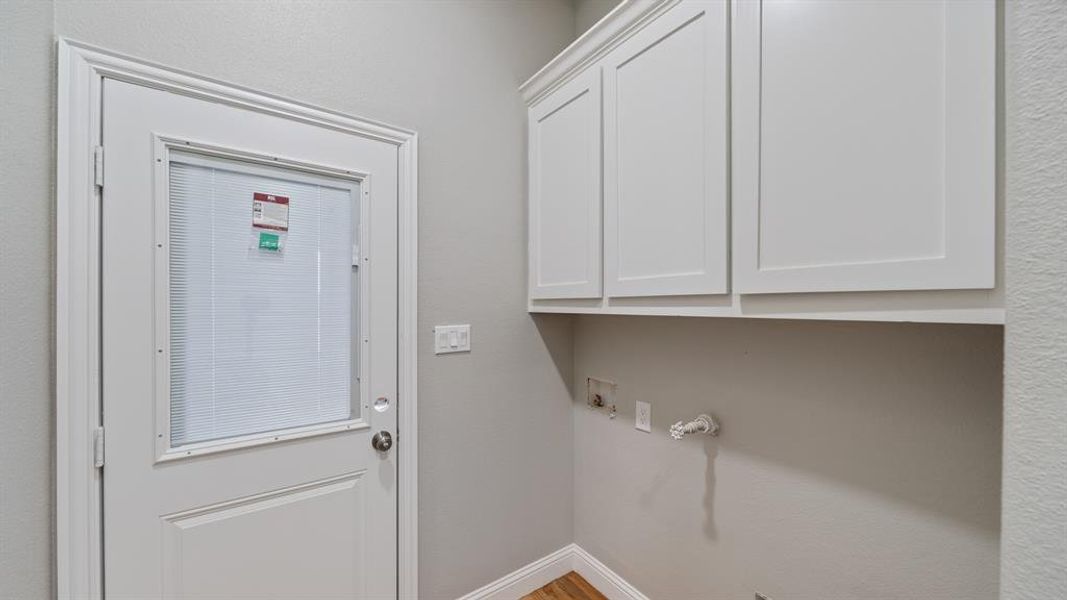 Washroom with hookup for a washing machine, cabinet space, and baseboards