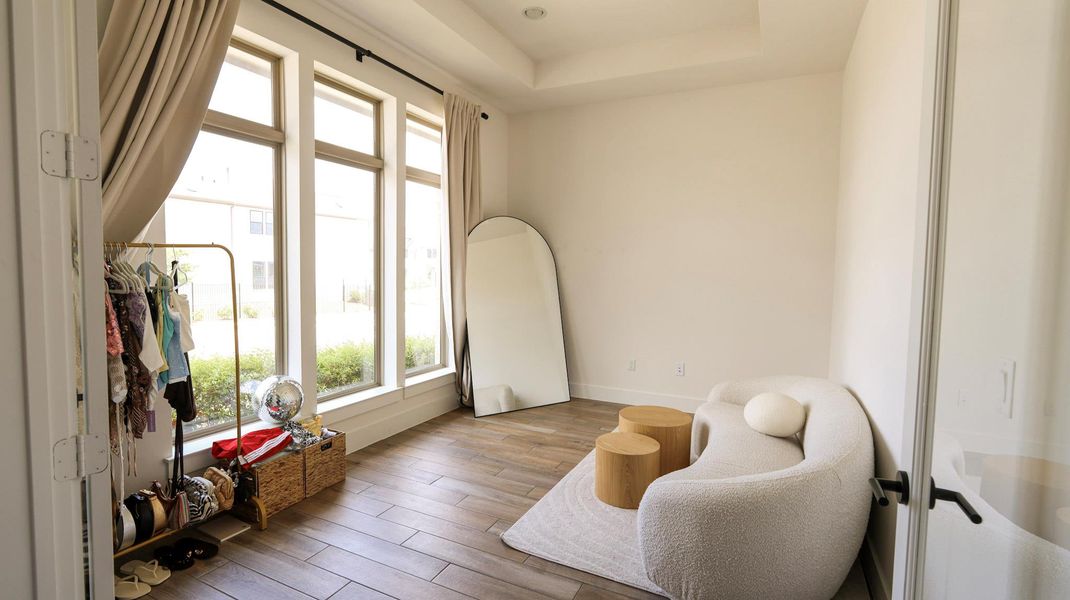 Sun-filled room boasts a graceful tray ceiling, creating an inviting and airy atmosphere. Sun-filled room boasts a graceful tray ceiling, creating an inviting and airy atmosphere.