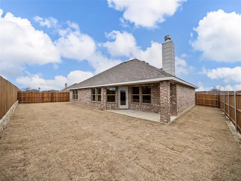 Back of property featuring a fenced backyard, a patio, brick siding, a chimney, and a shingled roof Back of property featuring a fenced backyard, a patio, brick siding, a chimney, and a shingled roof