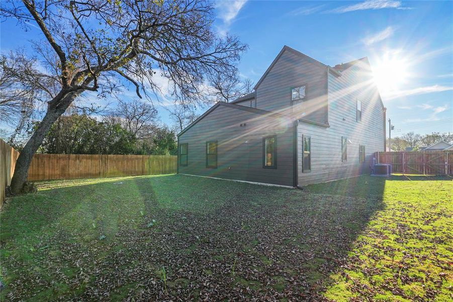 View of side of home with a fenced backyard and a central AC unit