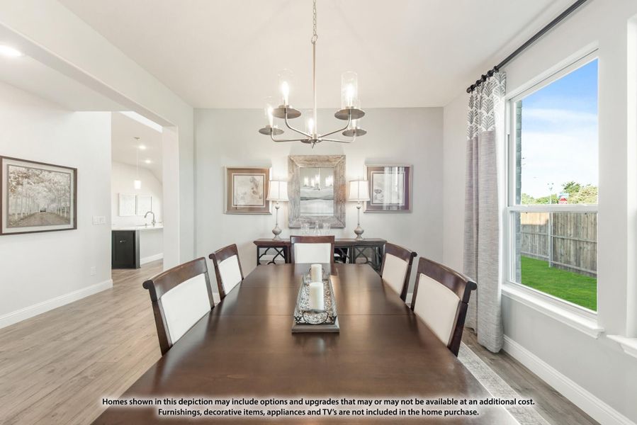 Dining room with dark wood table, eight chairs, chandelier, and large window with backyard view