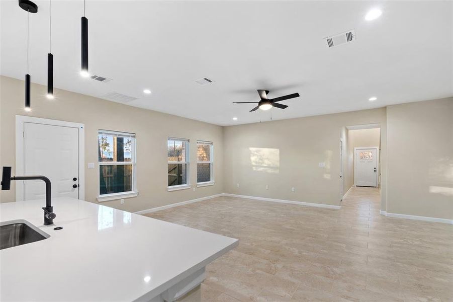 Kitchen featuring pendant lighting, ceiling fan, and sink