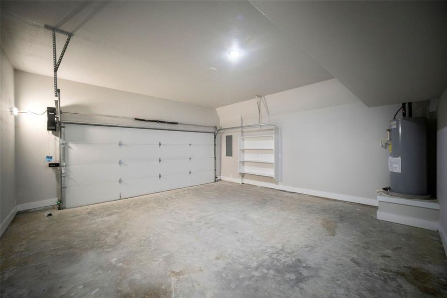 Garage featuring baseboards and water heater