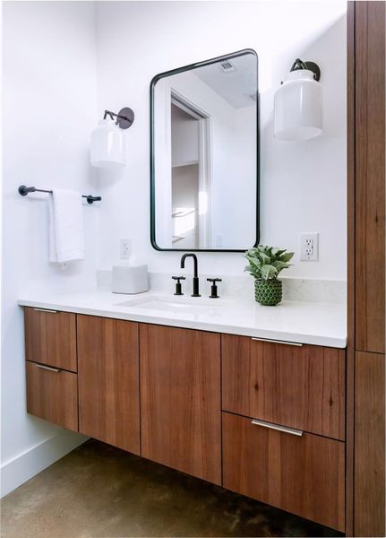 Elegant vanity area with custom cabinetry, quartz countertops, and sleek black hardware for a refined modern look. Elegant vanity area with custom cabinetry, quartz countertops, and sleek black hardware for a refined modern look.