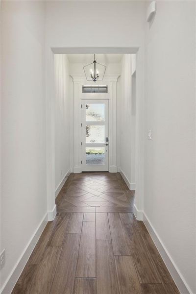 Doorway featuring wood-type flooring and a chandelier