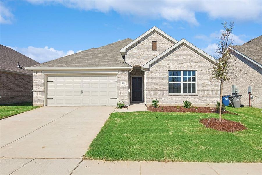 View of front of house featuring a garage and a front lawn