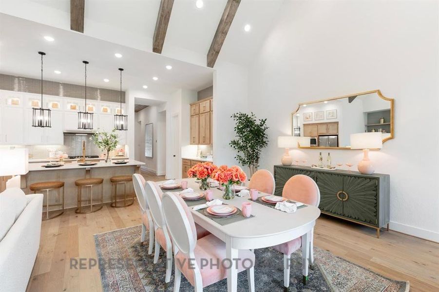 Dining area featuring recessed lighting, light wood-style flooring, beamed ceiling, and a towering ceiling