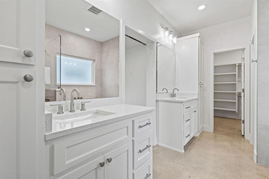 Full bath featuring two vanities, a spacious closet, concrete flooring, and recessed lighting