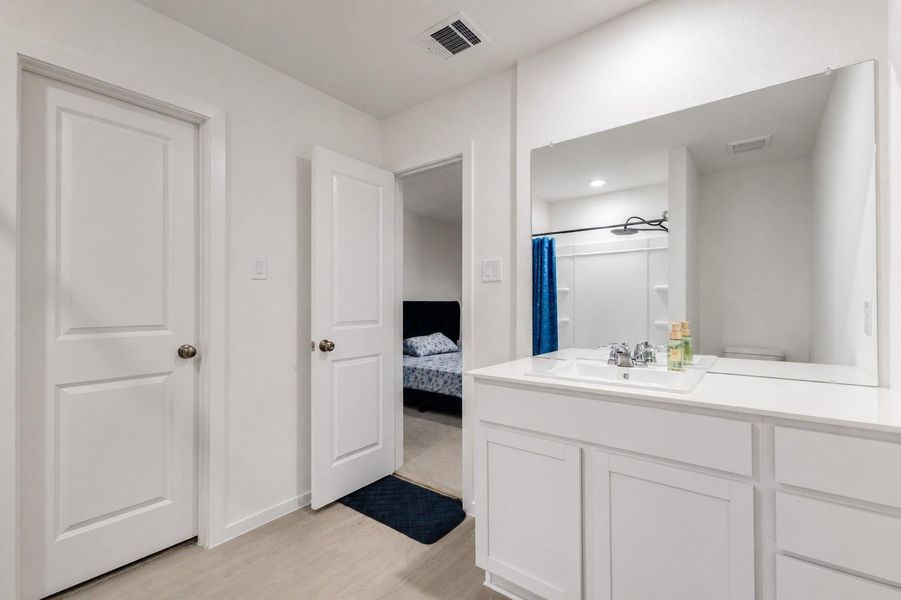 Expansive vanity with ample counter space and oversized mirror, providing a clean and functional layout for everyday use.
