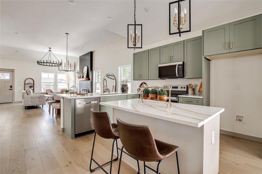 Kitchen with a chandelier, pendant lighting, light wood finished floors, and recessed lighting