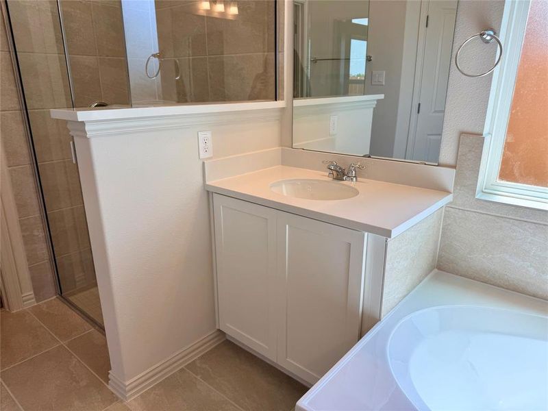 Bathroom featuring a white vanity with an integrated sink, polished chrome faucet, and a large mirror