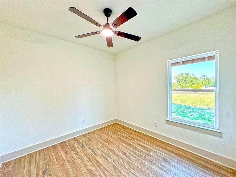 Unfurnished room with light wood-type flooring and ceiling fan