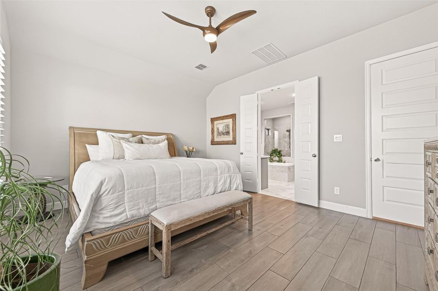 Spacious, welcoming primary bedroom featuring a spa-like ensuite bathroom. (Note: Photo is staged; property is currently vacant.) Spacious, welcoming primary bedroom featuring a spa-like ensuite bathroom. (Note: Photo is staged; property is currently vacant.)