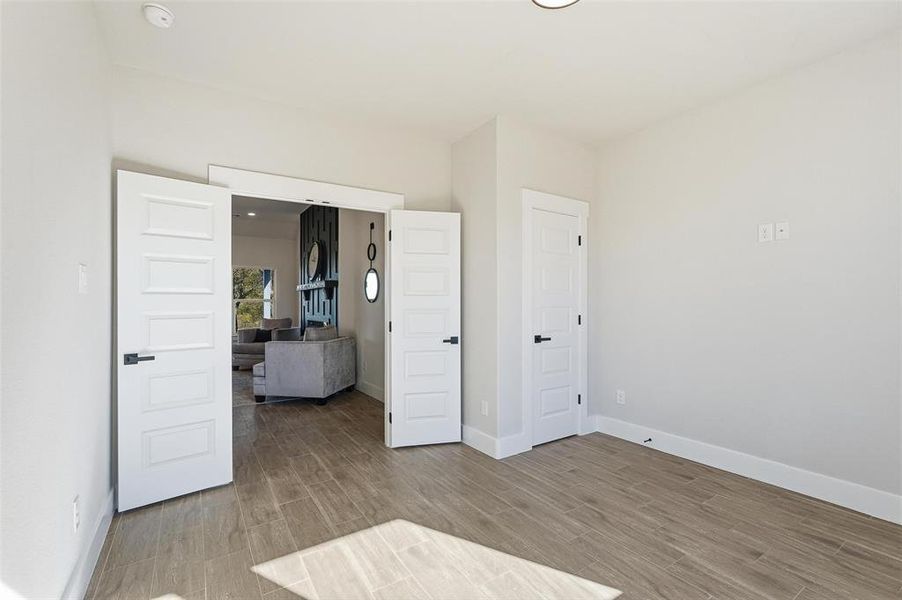 Unfurnished bedroom with wood tiled floors and baseboards