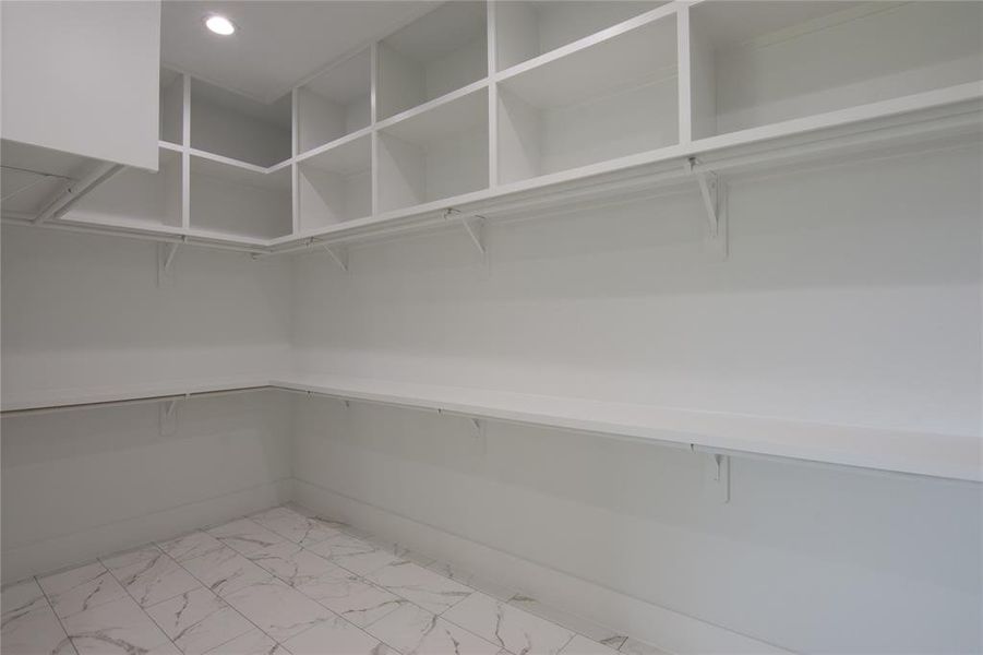 Spacious walk-in closet with ample shelving and storage space. Spacious walk-in closet with ample shelving and storage space.