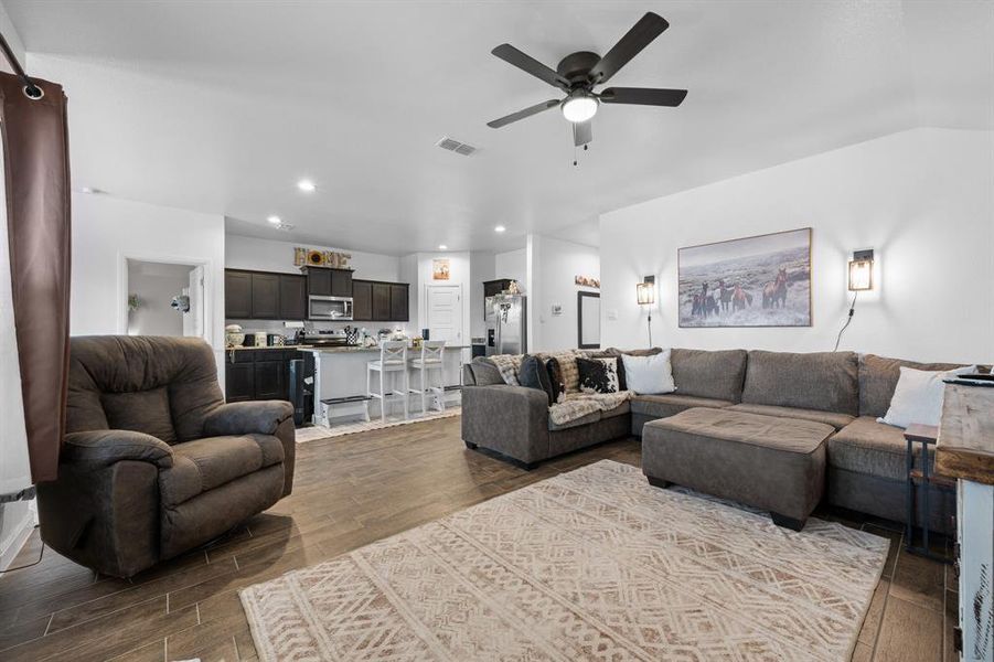 Living area with wood tiled floors, ceiling fan, and recessed lighting Living area with wood tiled floors, ceiling fan, and recessed lighting