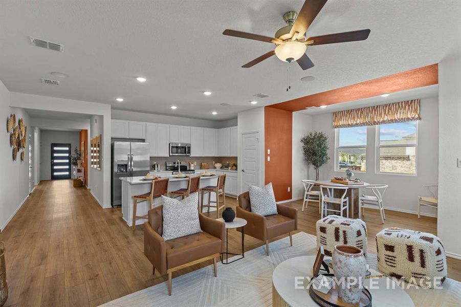 Living room with ceiling fan, sink, and light wood-type flooring