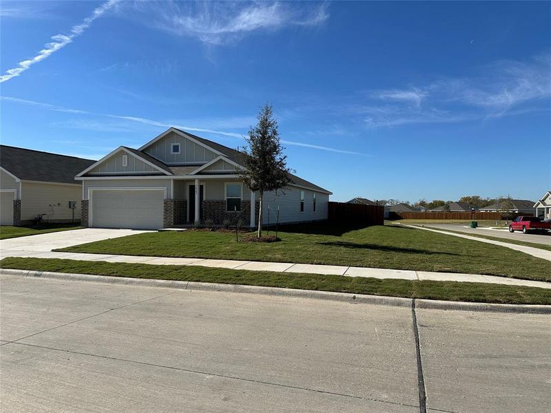 View of front of property with a front yard and a garage