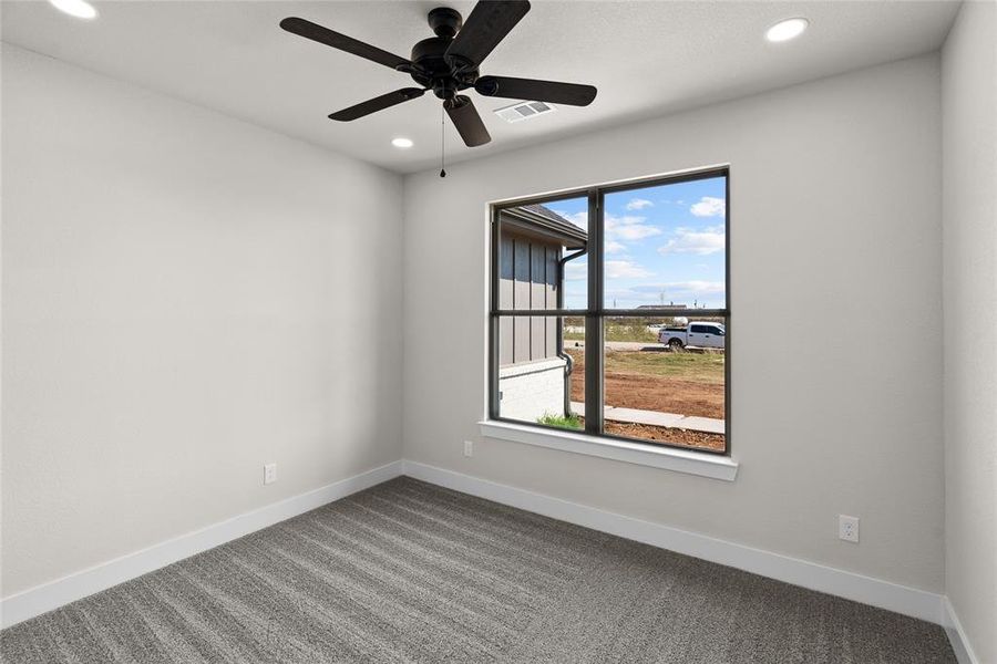 Carpeted spare room featuring ceiling fan