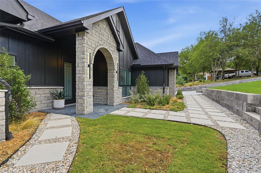 Contemporary exterior featuring dark vertical siding and light-colored stone accents